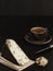 A slice of fresh sliced homemade craft goat cheese with walnut closeup. On the back black background is an espresso cup. Dessert