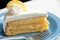 Slice of frosted lemon cake on a blue plate