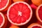 Slice of grapefruit. Red grapefruit background. Composition of half Orange.