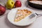 Slice of homemade apple pie with fork and fresh apples on light
