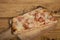 Slice of homemade pizza with frankfurt on a wooden cutting board