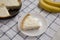 Slice of Homemade Tasty Banana Cream Pie on a white wooden table, low angle view. Close-up