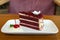 Slice of homemade velvet red cake decorated with cream on white
