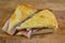 Slice of italian focaccia bread stuffed with speck ham and taleggio cheese on wooden cutting board