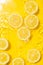 Slice of lemon underwater or in water with splashing and droplet top view flat lay on yellow background