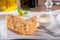 Slice of Napoleon cake close-up on white  dish with mint leaf and bowl of cream sauce