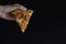 Slice of new york style pizza with pepperoni isolated black background. The concept of fast food