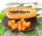 Slice papaya fruit on green leaf