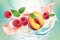 Slice peach and raspberries with milk yogurt splashes close-up on blue background. splashing. Healthy food, dairy dessert. Art