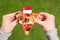 A slice of pizza in female hands with Singapore flag in the form of a toothpick. Lunch on the green grass. China. Concept.