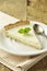 Slice of plain cheesecake on wooden table. Homemade dessert