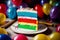 A Slice Of Rainbow Cake On A Plate Surrounded By Balloons. Generative AI