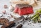 Slice of Raw Beef Topside Joint with Salt and Pepper on round chopping board with fork and knife, asparagus tips and garlic