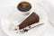 Slice of Sacher cake in plate with coffee