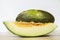 Slice of Santa Claus melon in front of the fruit