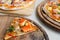 Slice of Seafood Italian Pizza and Hawaiian Chicken BBQ Italian Pizza and Bacon,Garlic and Chilli Italian Pizza on wood dish