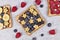 Slice of spelt toast bread topped with blueberry fruits, banana slices in shape of stars and puffed quinoa grain