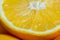 Slice of split orange fruit in an appetizing-looking macro photo.