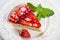 Slice of strawberry tart with fresh strawberries and mint leaf