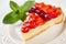 Slice of strawberry tart with fresh strawberries and mint leaf