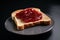 a slice of toast, spread with strawberry jam