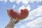 Slice of watermelon in hand against the blue sky. Watermelon in hands against a blue sky with clouds. Piece of watermelon