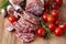 Sliced Air-dried salami with rosemary and cherry tomatoes - wood background