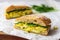 sliced baguette sandwich with egg salad on parchment paper