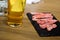 Sliced beef for barbecue grill with glass of beer