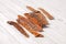 Sliced beef udder cut for pieces, dehydrated and lying down on wooden white background.