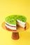 Sliced Birthday cake on the wooden cake stand. Beautiful sponge cake on the paper background. Copy space. Food photography for