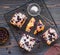 Sliced blackcurrant corn cake sprinkled with powdered sugar on a black wire rack on a dark wooden background. Baking cornmeal