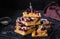 Sliced blackcurrant corn cake sprinkled with powdered sugar on a black wire rack on a dark wooden background. Baking cornmeal