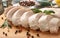 Sliced boiled chicken fillet with herbs and spices on wooden board, closeup