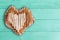 Sliced bread loaf shaped as heart over green wood