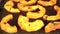 Sliced butternut squash pumpkin grilled on electric grill plate, detail on smoke coming from yellow pieces with seasoning