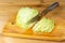 Sliced cabbage, knife on cutting board, half cabbage head. Fresh vegan food. Sliced cabbage on a cutting board. Wooden background