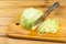 Sliced cabbage, knife on cutting board, half cabbage head. Fresh vegan food. Sliced cabbage on a cutting board. Wooden background