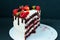 Sliced cake on black background, with strawberry raspberries. Dietary white cream, with chocolate flavors. Puffed on the