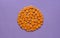 Sliced carrots in a circle on purple background