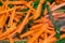 Sliced carrots and green onions frying in a pan