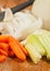 Sliced carrots, onion and cellery on a wood cutting board