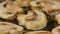 Sliced champignon mushrooms are fried in a hot pan in close up. Golden slices of champignons are fried in olive oil