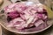 Sliced and chopped red onions and shallots on stainless steel plate.