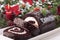 Sliced Christmas yule log cake on plate with candle