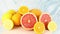 Sliced citrus fruit, lemons, oranges, grapefruits on cutting board on blue background