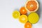Sliced citrus on a white background with a glass of fresh juice. Grapefruit, lemon, tangerine.