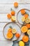 Sliced colorful citruses on handmade plates on a white wooden table