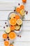 Sliced colorful citruses on a plate served on a white wooden table.