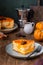 Sliced cottage cheese casserole with pumpkin layer on a ceramic plate on a brown wooden background. Pumpkin recipes. Thanksgiving